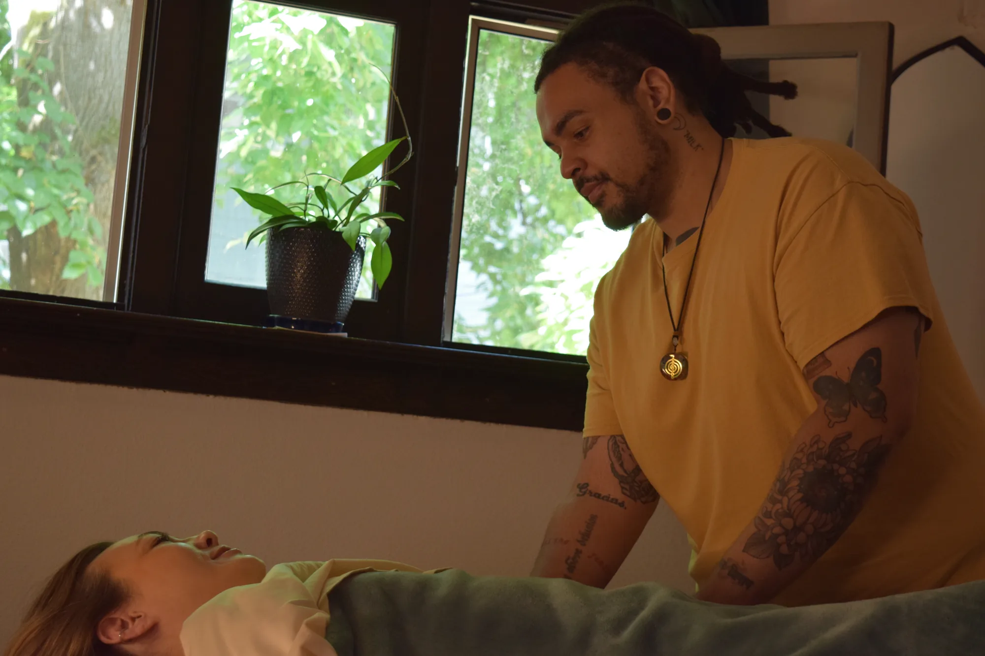 Jonathan providing attentive massage while a client rests beneath a warm blanket.