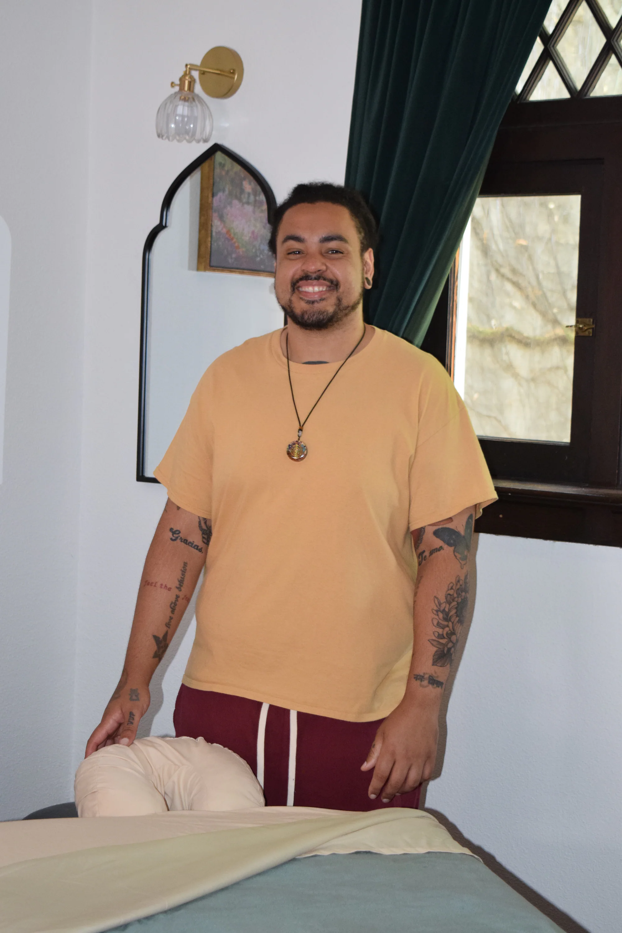 Jonathan smiling beside the prepared massage table in his Northwest Portland treatment room.