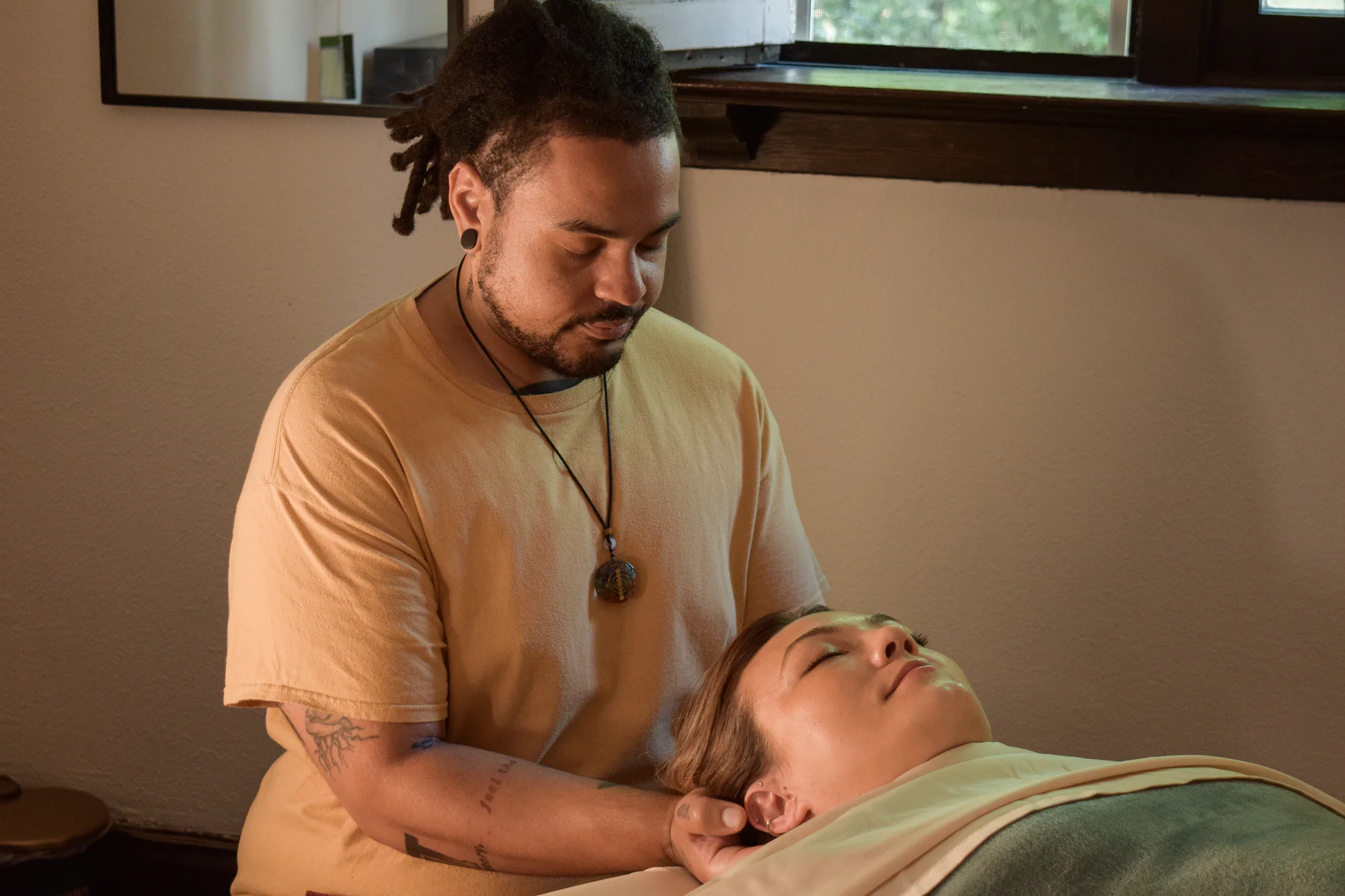 Jonathan supporting a client’s head during restorative massage.