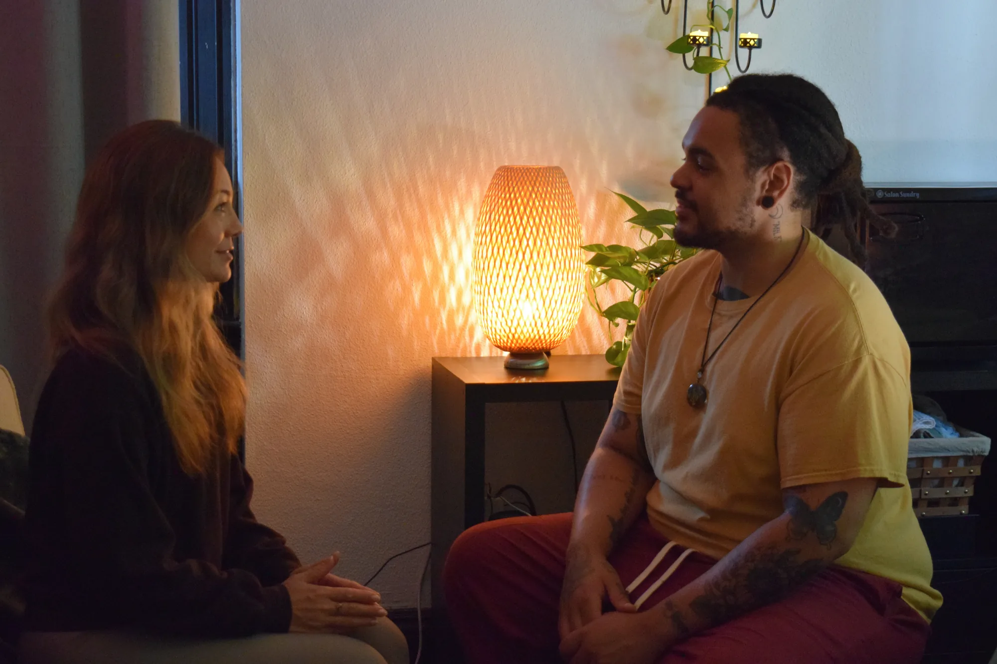 Jonathan and a client seated across from each other in warm conversation before massage.
